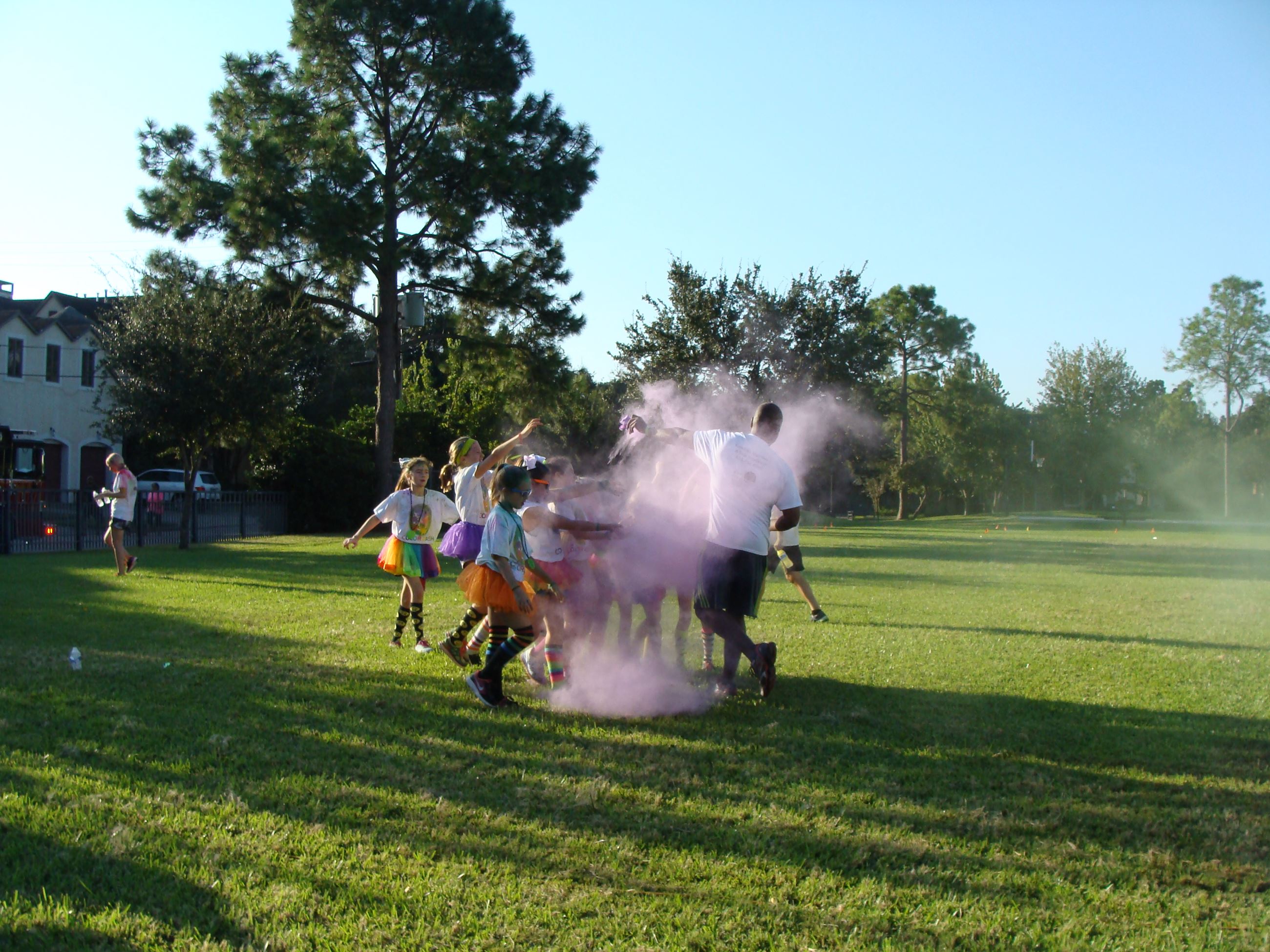 Small group of children in a cloud of color powder
