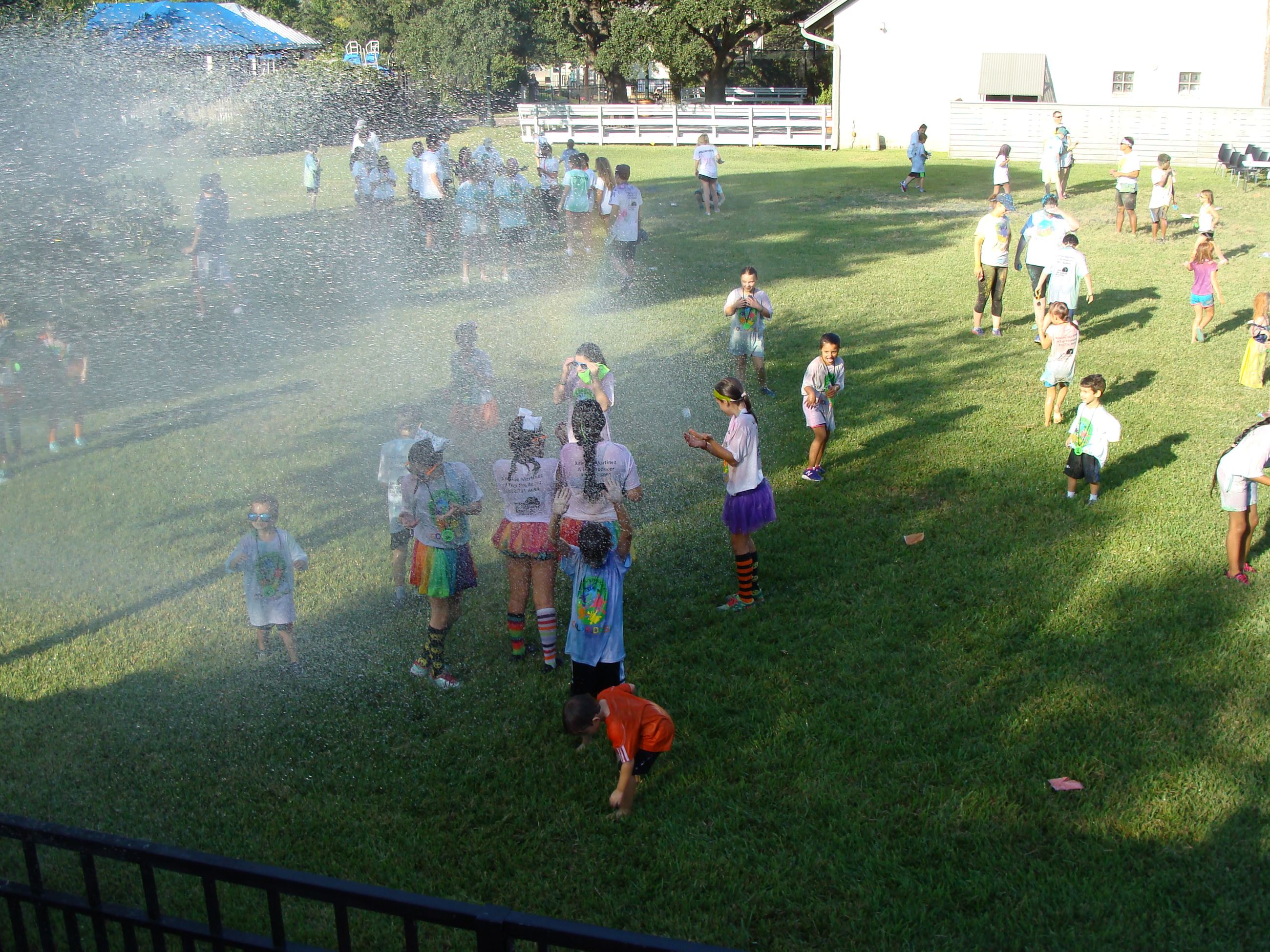 Group of children being sprayed with water from the fire truck
